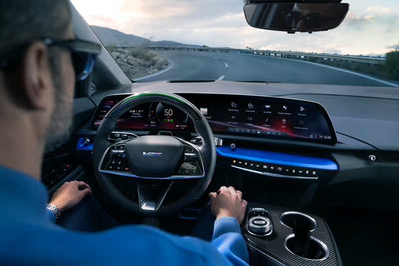 Front View of the 2026 OPTIQ-V Driving Through the Dusk Utilizing its Headlights | Walker-Jones Cadillac in Waycross GA